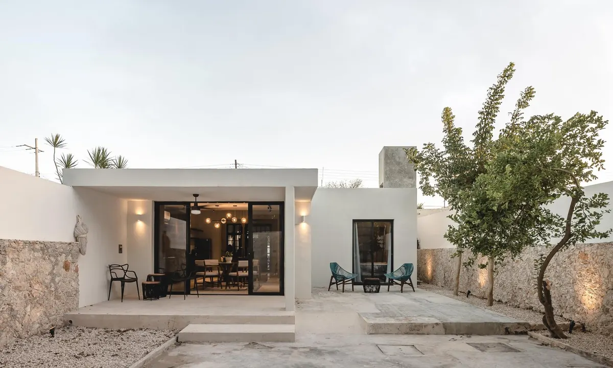 Rear terrace of Scott House with sliding glass doors, stone walls and garden