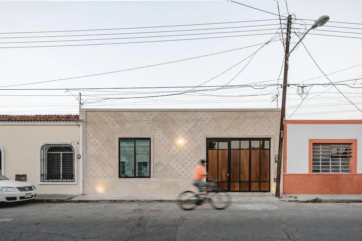 Restored façade with carved plaster, steel-framed window and timber garage doors