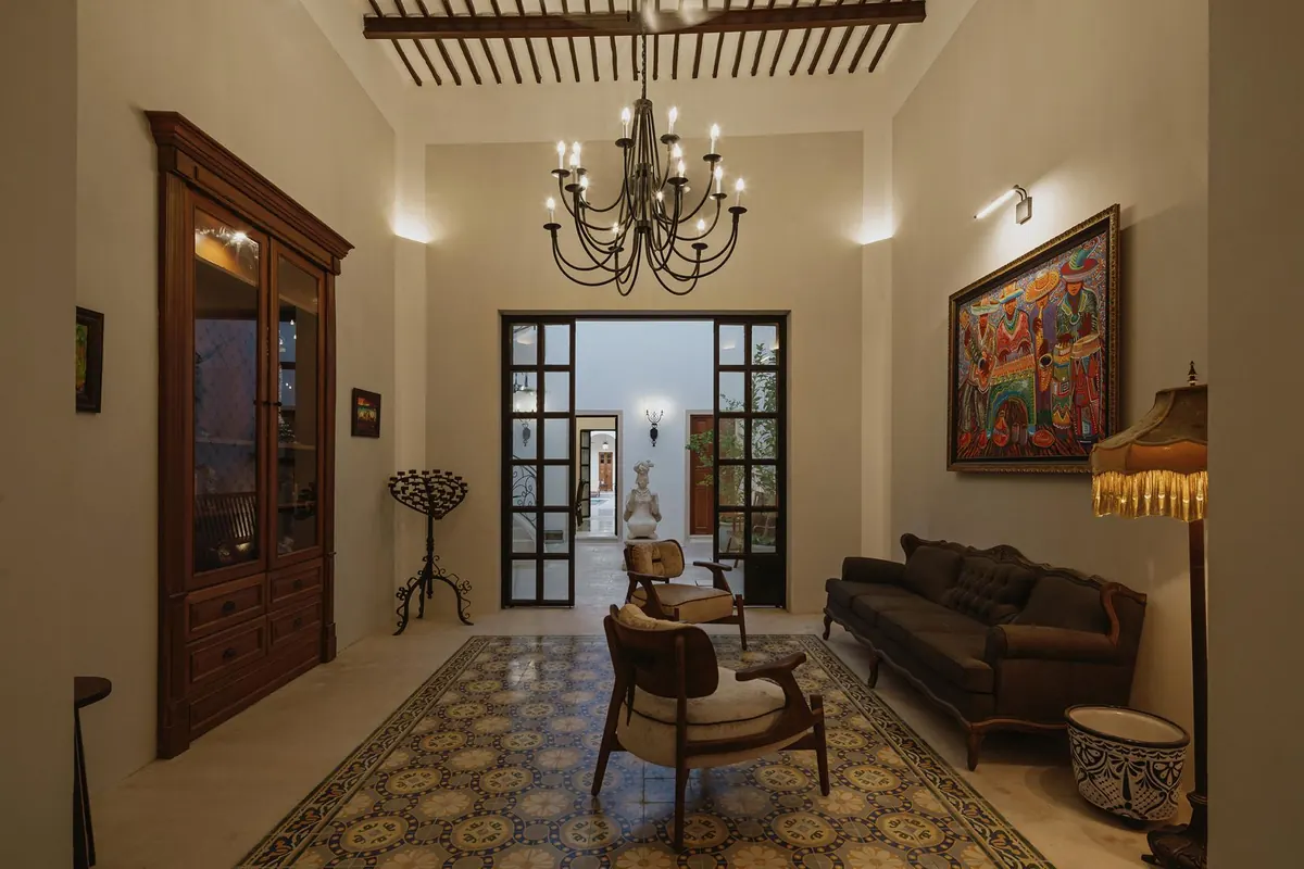Living room with timber beam ceiling, chandelier and cement-tile floor, looking into the patio