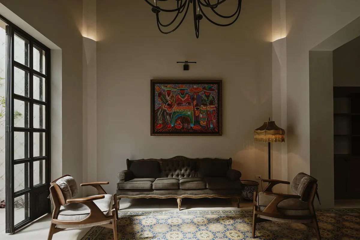 Sitting room with antique sofa, Mexican painting and steel-framed doors