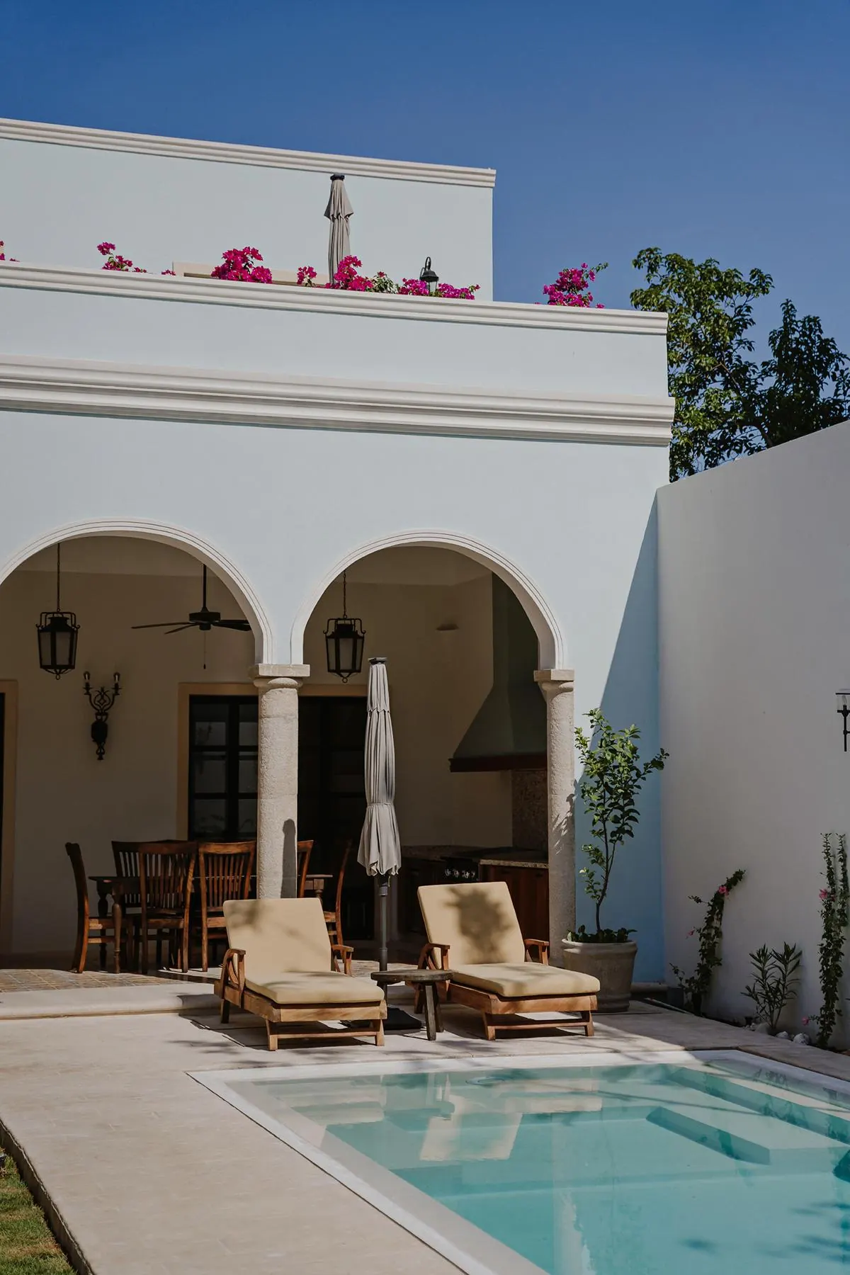 Arched terrace and pool with loungers and bougainvillea